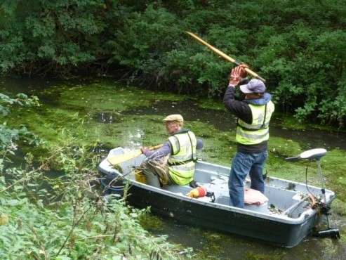 Men in a boat clearing the river